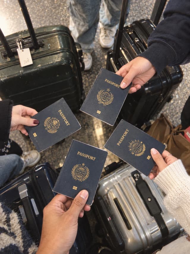 Friends holding their passports above their luggage