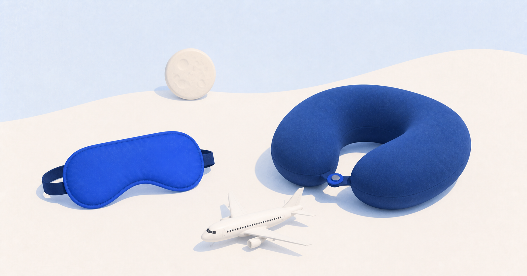 A blue travel pillow, sleep mask, small airplane, and cream moon arranged in a bright studio scene